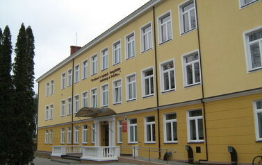 Zdjęcie przedstawia frontowy wejście, budynek szkoły od lewej strony