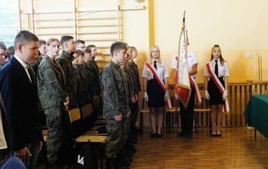 Na zdjęciu poczet sztandarowy szkoły oraz uczniowie klasy z innowacja pedagogiczną edukacja wojskowa podczas śpiewania hymnu państwowego